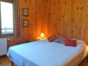 - une chambre avec un grand lit et des murs en bois dans l'établissement Chalet Arêches-Beaufort, 5 pièces, 6 personnes - FR-1-342-225, à Beaufort