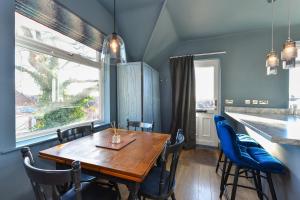 una sala da pranzo con tavolo in legno e sedie blu di Fairview Boutique Apartments in West Bridgford Centre a Nottingham