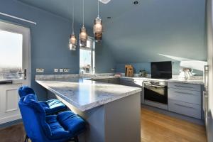 a kitchen with a large counter and blue walls at Fairview Boutique Apartments in West Bridgford Centre in Nottingham