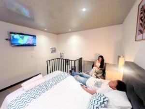 Una donna giace su un letto in una camera da letto di Encantocandelaria a Bogotá