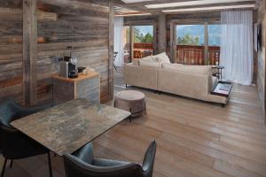 a living room with a couch and a table at Aïda Hôtel & Spa - "Adults Only" Relais & Châteaux in Crans-Montana