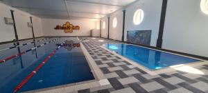 een groot zwembad in een gebouw met een zwembad bij MishyN-City Hotel in Dobrowlany
