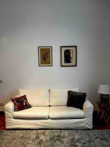 a white couch in a living room with two pictures on the wall at Elegante appartamento in centro in Milan