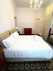 a large white bed in a room with a chandelier at Elegante appartamento in centro in Milan