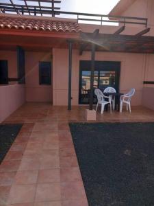 een patio met 2 stoelen en een tafel in een huis bij Casa el Hierro in Lajares