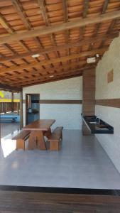 eine Terrasse mit einem Tisch und Bänken sowie eine Küche in der Unterkunft Casa de Praia Recanto do Atlântico in Nova Viçosa