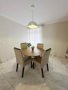 a dining room with a wooden table and chairs at Apartamento na região céntrica in Foz do Iguaçu