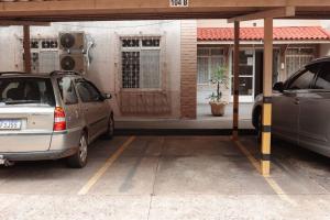 two cars parked in a parking lot in front of a building at Apartamento na região céntrica in Foz do Iguaçu