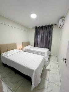 a room with two beds and a window at Apartamento na região céntrica in Foz do Iguaçu