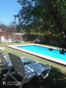 a pair of lawn chairs next to a swimming pool at Habitación matrimonial deluxe Casa Tierra Elquina in Vicuña