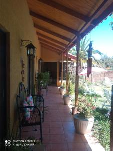 un porche con sillas y macetas. en Habitación matrimonial deluxe Casa Tierra Elquina, en Vicuña