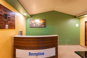 a reception desk in a room with a green wall at Treebo Trend Salt Water Beach Resort in Dapoli