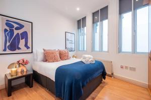 Welcome London Theatreland في لندن: غرفة نوم مع سرير وبطانية زرقاء