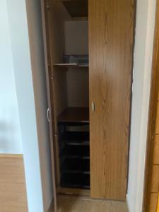 a closet with a wooden cabinet in a room at 2BR Cosy Apart in Satu Mare