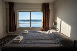 1 dormitorio con 1 cama grande y toallas. en HOTEL AUSONIA en San Carlos de Bariloche
