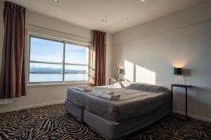 1 dormitorio con cama grande y ventana grande en HOTEL AUSONIA en San Carlos de Bariloche