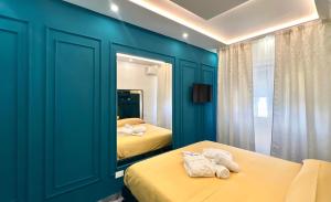 a blue room with two beds and a mirror at Serenity Suite in Montecatini Terme