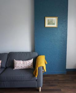 Sala de estar azul con pared azul y sofá en 3 Bedrooms - Spacious and friendly - City Center, en Caen