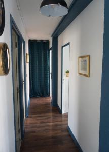 pasillo con paredes azules, suelo de madera y ventana en 3 Bedrooms - Spacious and friendly - City Center, en Caen