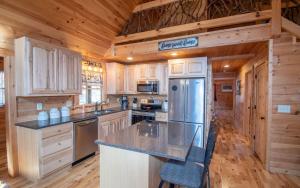 a kitchen with wooden cabinets and a stainless steel refrigerator at Relax & Unwind Hot-Tub 6 seater, Fire-Pit, Master King Bed, Near Wineries, Resort Amenities in Ellijay