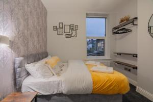 a bedroom with a bed with a yellow blanket at 2 Bed Garden Flat at Primal Estates Short Lets in Brighton in Brighton & Hove