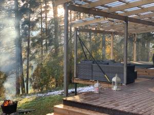 a pergola with a grill on a wooden deck at Tammemäe Spa Lodge 