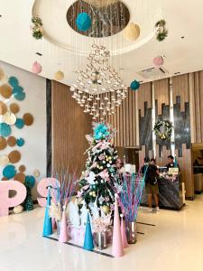 uma grande árvore de Natal numa sala com pessoas em Spacious Unit with City View at Iloilo Business Park em Iloilo