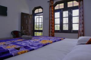ein Schlafzimmer mit einem Bett mit einer Decke darauf in der Unterkunft Sunrise home stay in Khajjiar 