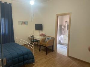 Pokój z sypialnią z biurkiem i łóżkiem w obiekcie OLEANDRI SUITE B&B w mieście Aprilia
