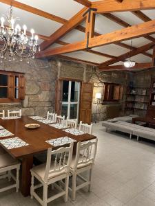 a dining room with a wooden table and white chairs at VILLA en PLAYA LIMENS in Cangas de Morrazo