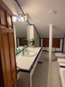 ein Badezimmer mit einem Waschbecken, einem WC und einem Spiegel in der Unterkunft VILLA en PLAYA LIMENS in Cangas