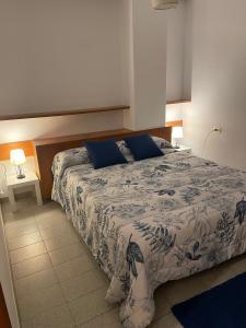 a bedroom with a large bed with blue pillows at VILLA en PLAYA LIMENS in Cangas de Morrazo