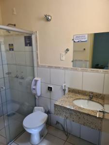 a bathroom with a toilet and a sink and a mirror at Hotel Beira Rio Aquidauana in Aquidauana +31 photos