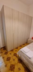 1 dormitorio con cama, armarios y suelo amarillo en Appartamento La Francigena, en Piacenza