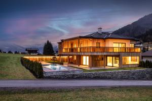 a house in the middle of a field with a pool at Central - Holiday Resort Flachau in Flachau