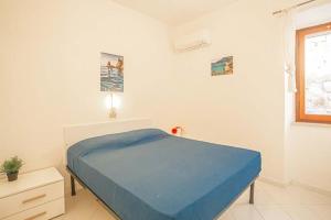 a bedroom with a blue bed and a window at Carla 1 in Campese