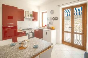 a kitchen with a counter top and a kitchen with red at Carla 1 in Campese