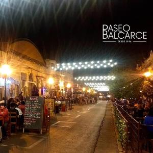 una strada di notte con persone sedute ai tavoli di ANDÉN FMA-Coliving a Salta