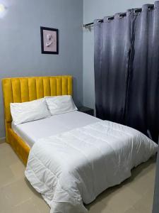 ein Schlafzimmer mit einem großen Bett mit einem schwarzen Vorhang in der Unterkunft MJ Apartments in Lekki