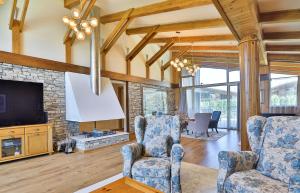 ein Wohnzimmer mit 2 Stühlen und einem TV in der Unterkunft Luxury Chalets Pirin Golf & Country Club in Bansko