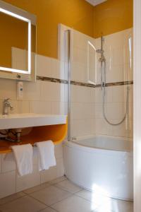 La salle de bains est pourvue d'une douche, d'une baignoire et d'un lavabo. dans l'établissement Cit'Hotel Sphinx - Hotel, à Montélimar