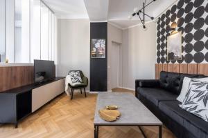 een woonkamer met een bank en een tafel bij Rigas29 - UrbanNest Bucharest in Boekarest