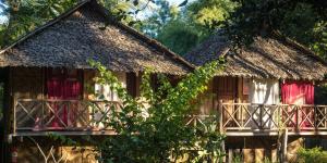 ein altes Haus mit Strohdach und Fenstern in der Unterkunft Sang Tong Huts in Mae Hong Son