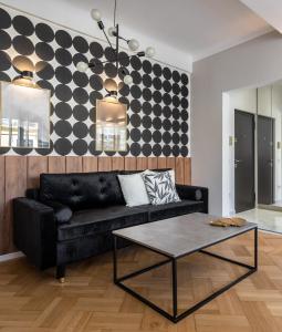 een woonkamer met een zwarte bank en een tafel bij Rigas29 - UrbanNest Bucharest in Boekarest