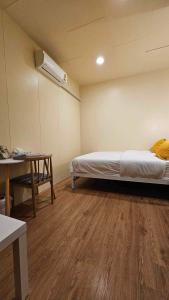 a room with a bed and a table in it at W District hostel in Bangkok