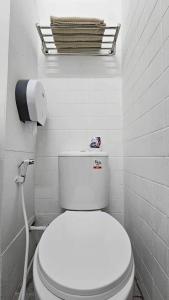 La salle de bains est pourvue de toilettes blanches avec un rouleau de papier toilette. dans l'établissement W District hostel, à Bangkok