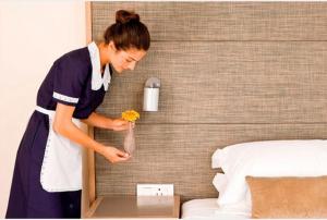 a woman holding a flower in a bag next to a bed at SH Home in Palma Campania