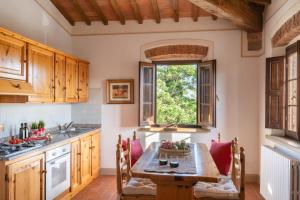a kitchen with a wooden table with a bowl of fruit on it at La Mandriola in Laiatico