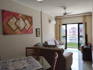 - un salon avec un canapé et une table dans l'établissement Apartamento no canto do forte, à Praia Grande