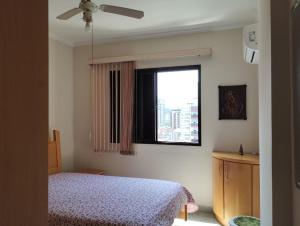 - une chambre avec un lit et une fenêtre dans l'établissement Apartamento no canto do forte, à Praia Grande